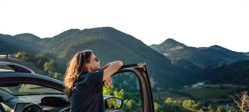 Car and Woman in Mountains
